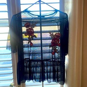 Medium black mesh blouse with floral appliqués.